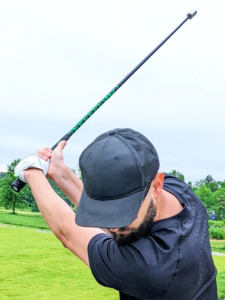 Man doing a golf swing on the green