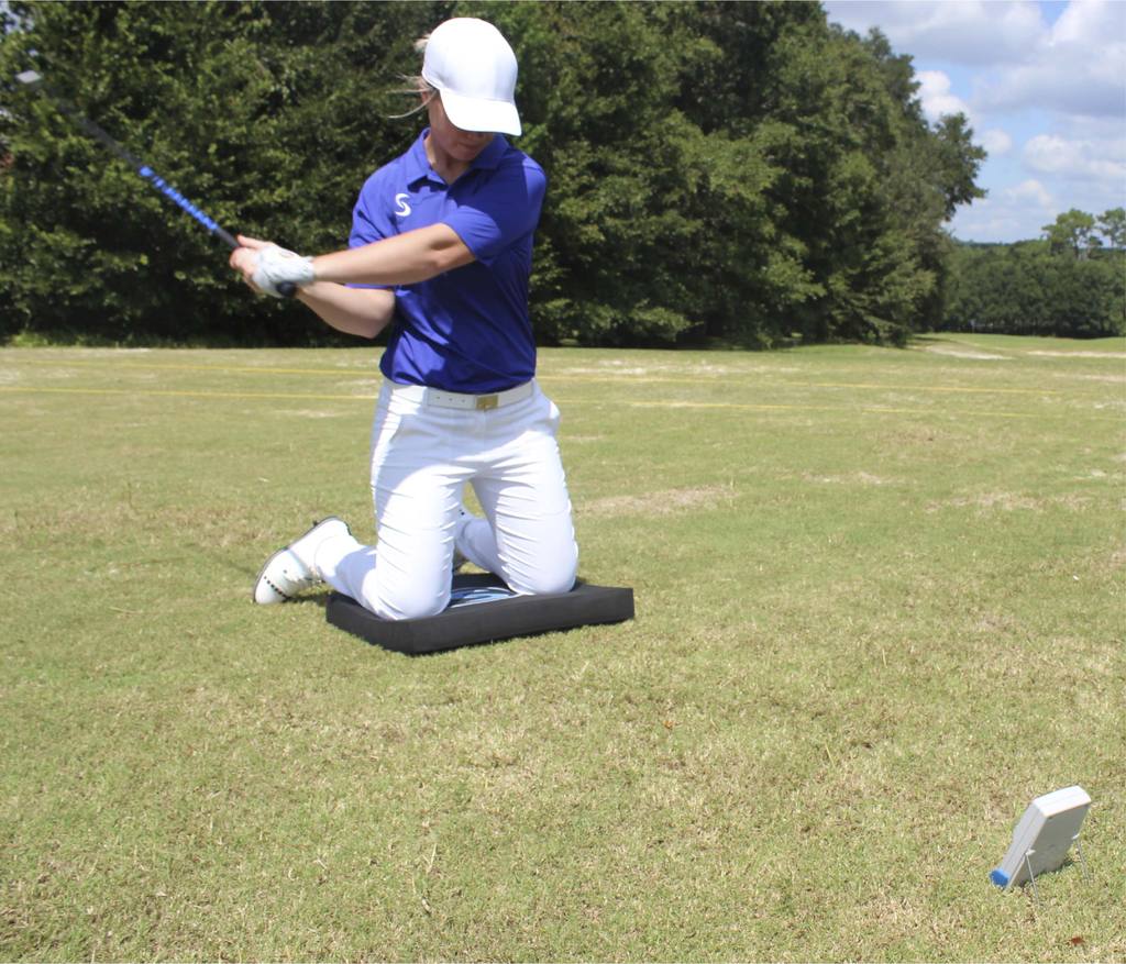 A demo shot of a lady golfer using the black stability pro mat.